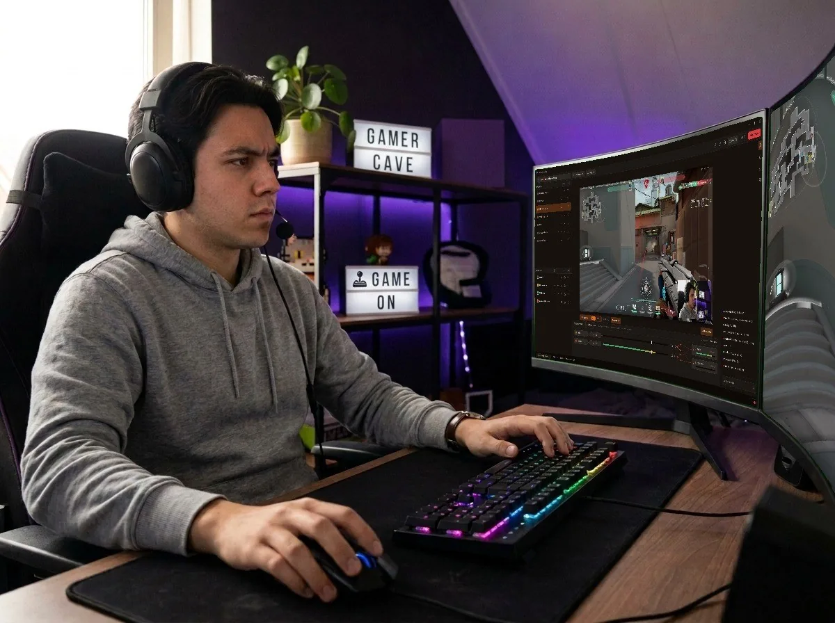 A streamer playing a shooter with Acrux Studio open on his monitor, live, with chat and the mixer